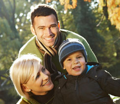 Mother and father smiling and embracing child