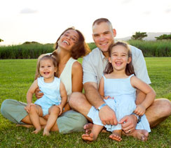 Father and mother sitting with their kids in the grass